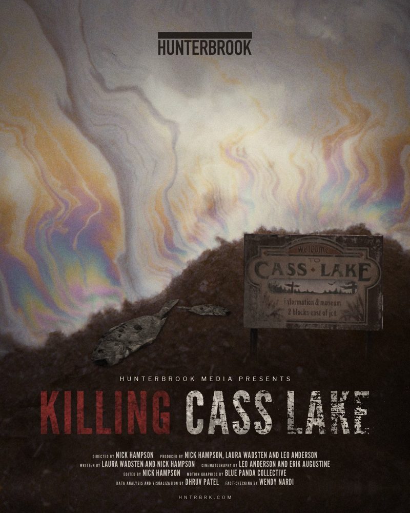 Killing Cass Lake film poster: an oily, iridescent sky over a dirt mound with dead fish and a weathered Welcome to Cass Lake sign